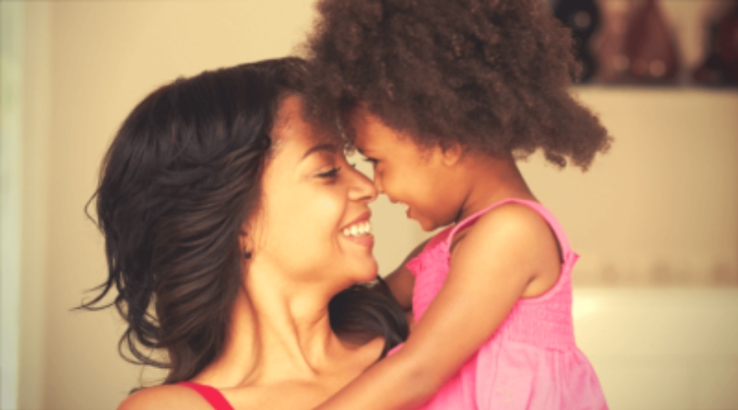 Mãe e filha se abraçando e sorrindo