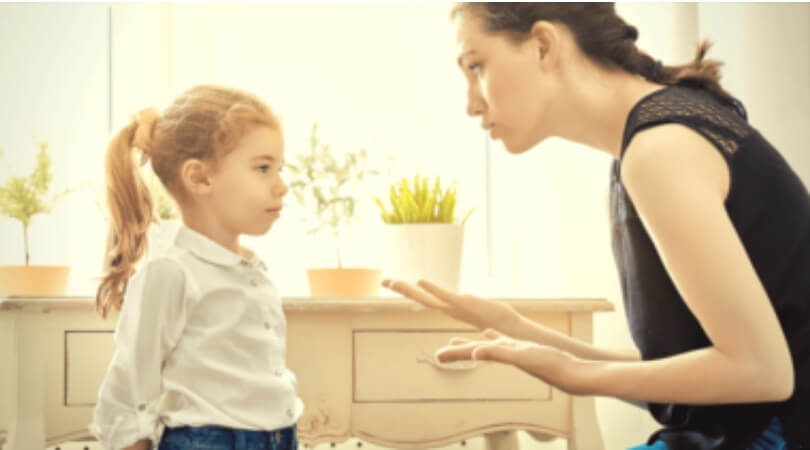 Mãe conversando com a filha mostrando a mão para ela