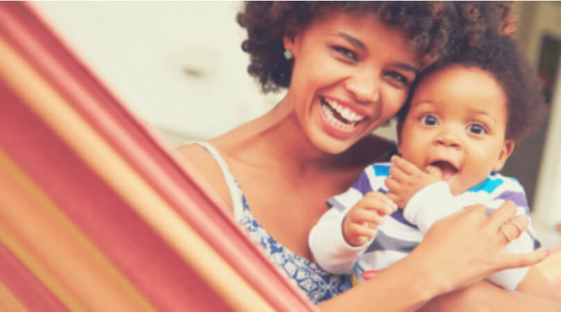 Mulher abraçando uma criança e sorrindo