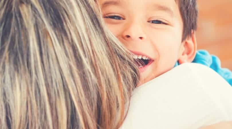 criança sorri e abraça a mãe